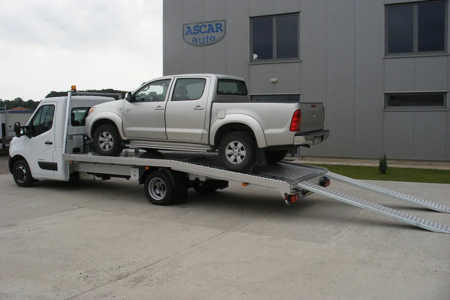 Autoplatformă cu rampe coborâte, în fața halei ASCAR AUTO